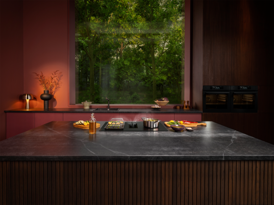 Food is being prepared on an induction hob in a kitchen.